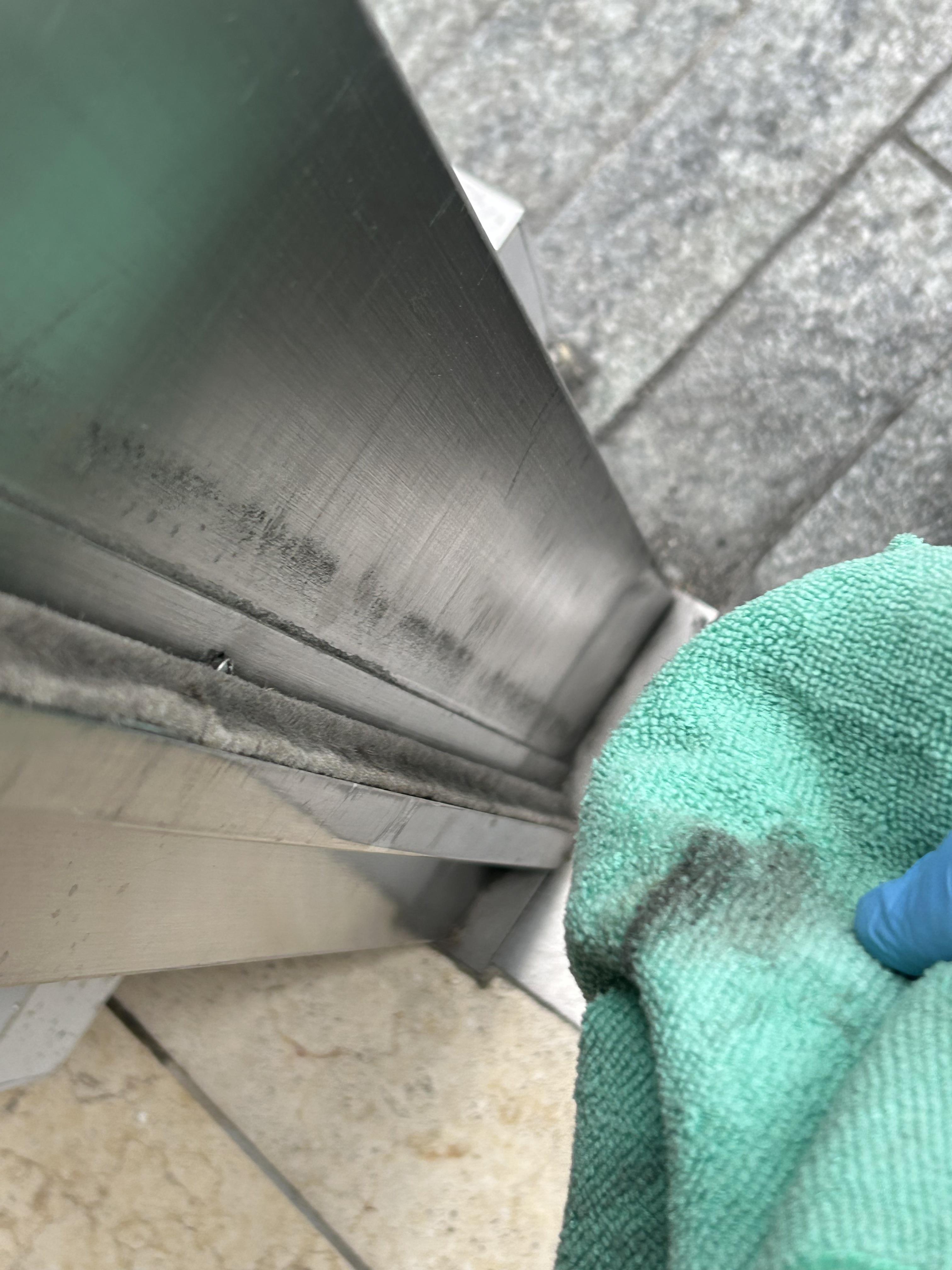 Commercial window track being cleaned with a microfiber cloth